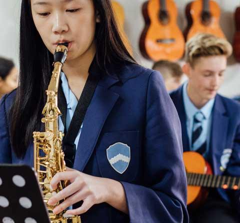 Girl playing saxophone and boy playing guitar 